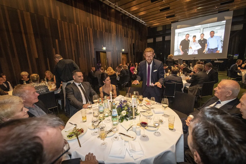 Tischzauberei beim festlichen Dinner: Gäste staunen, Simabu steht am runden Tisch