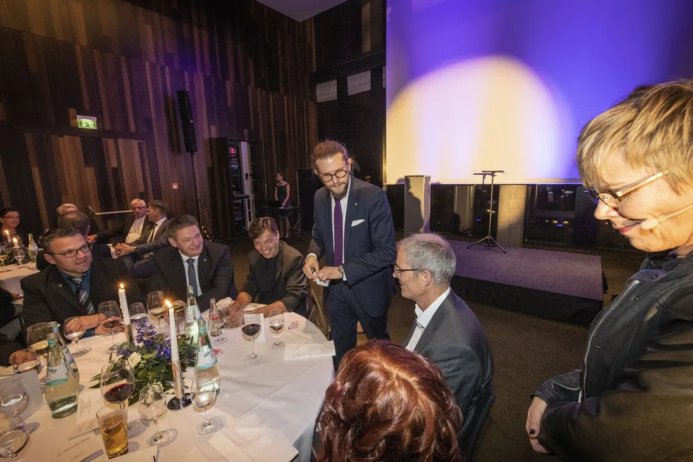 Zauberer Simabu am Tisch eines Festabends – Close-Up Magie zwischen Gläsern und Kerzen