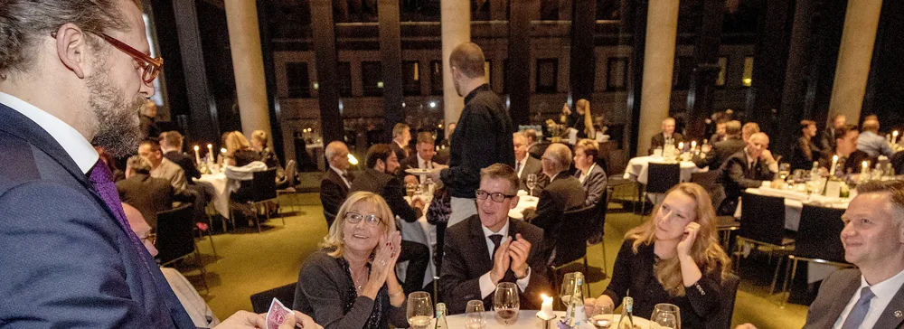 Tischzauberei beim Gala-Dinner: Zauberer Simabu am festlich gedeckten Tisch, Gäste applaudieren