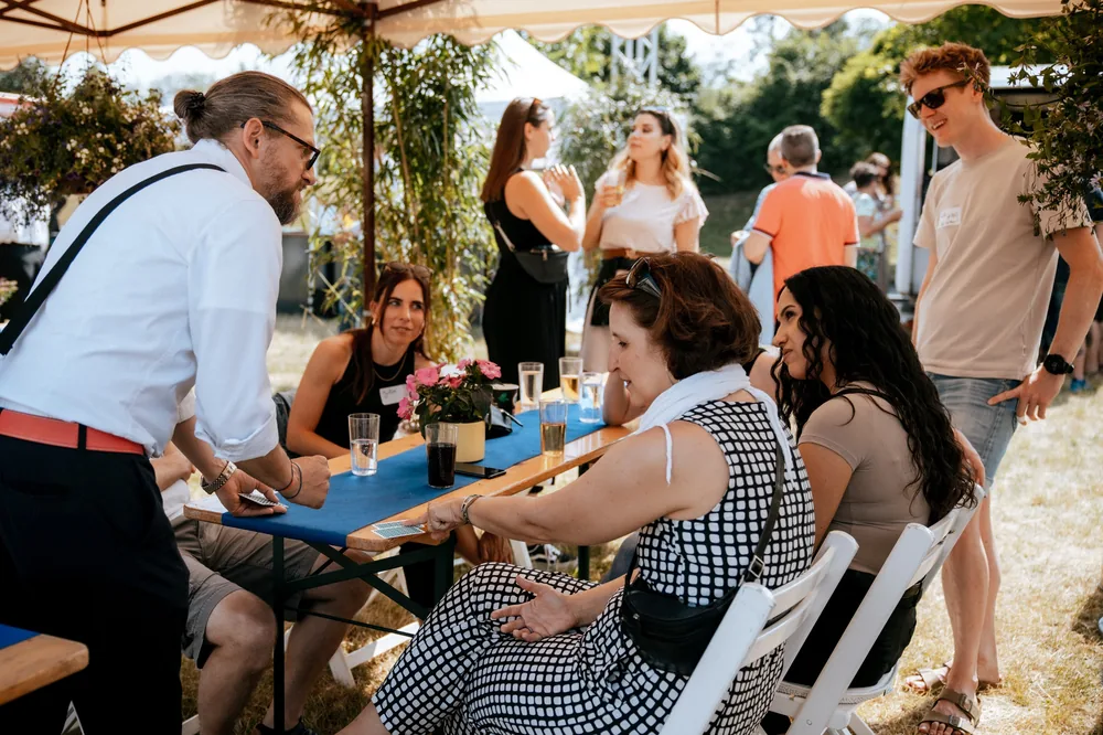 Close-Up Zauberei bei einer Gartenparty: Simabu zaubert am Tisch für die Gäste