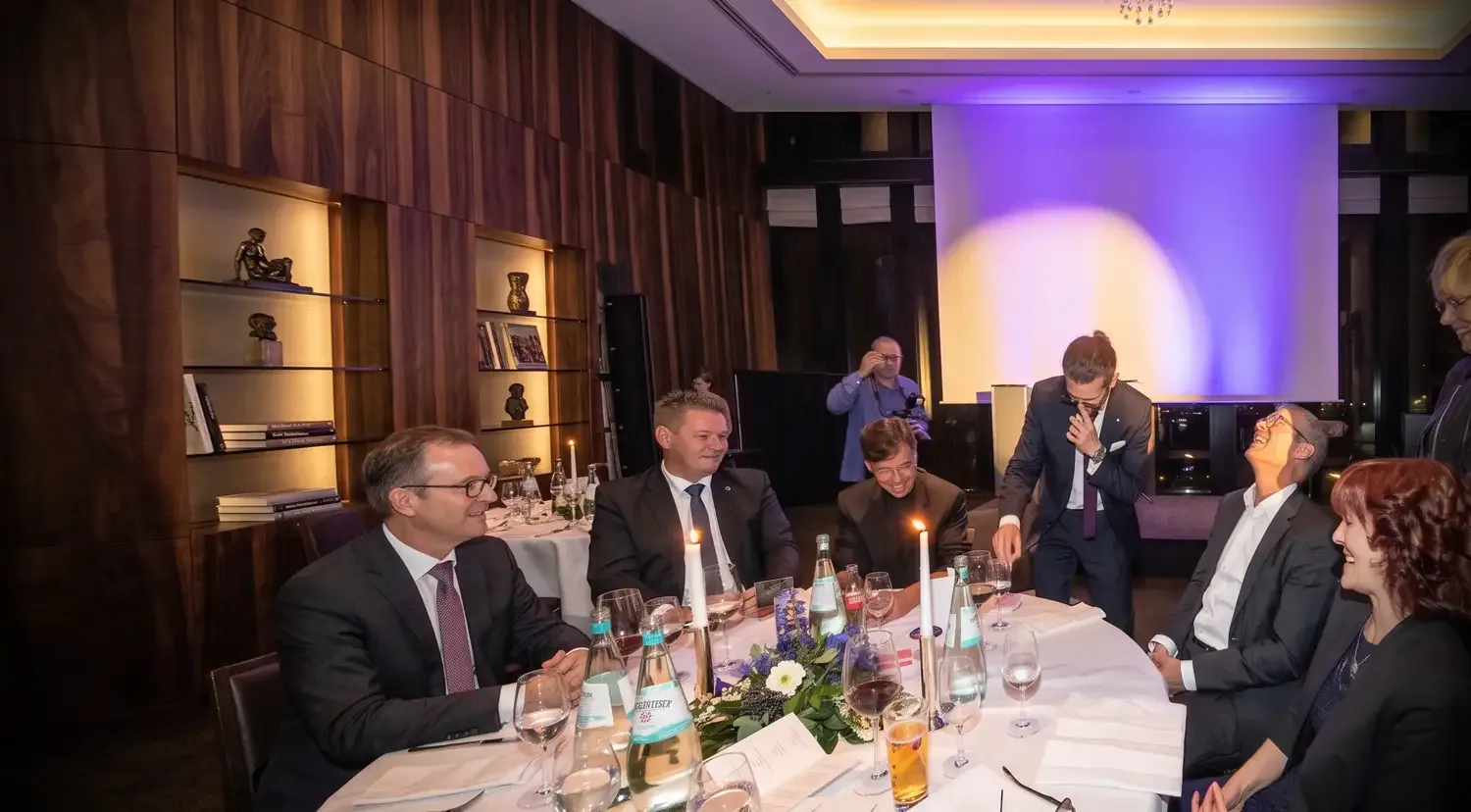 Zauberer Simabu bei einer Firmenfeier – Tischzauberei am festlich gedeckten Tisch, Gäste lachen und staunen